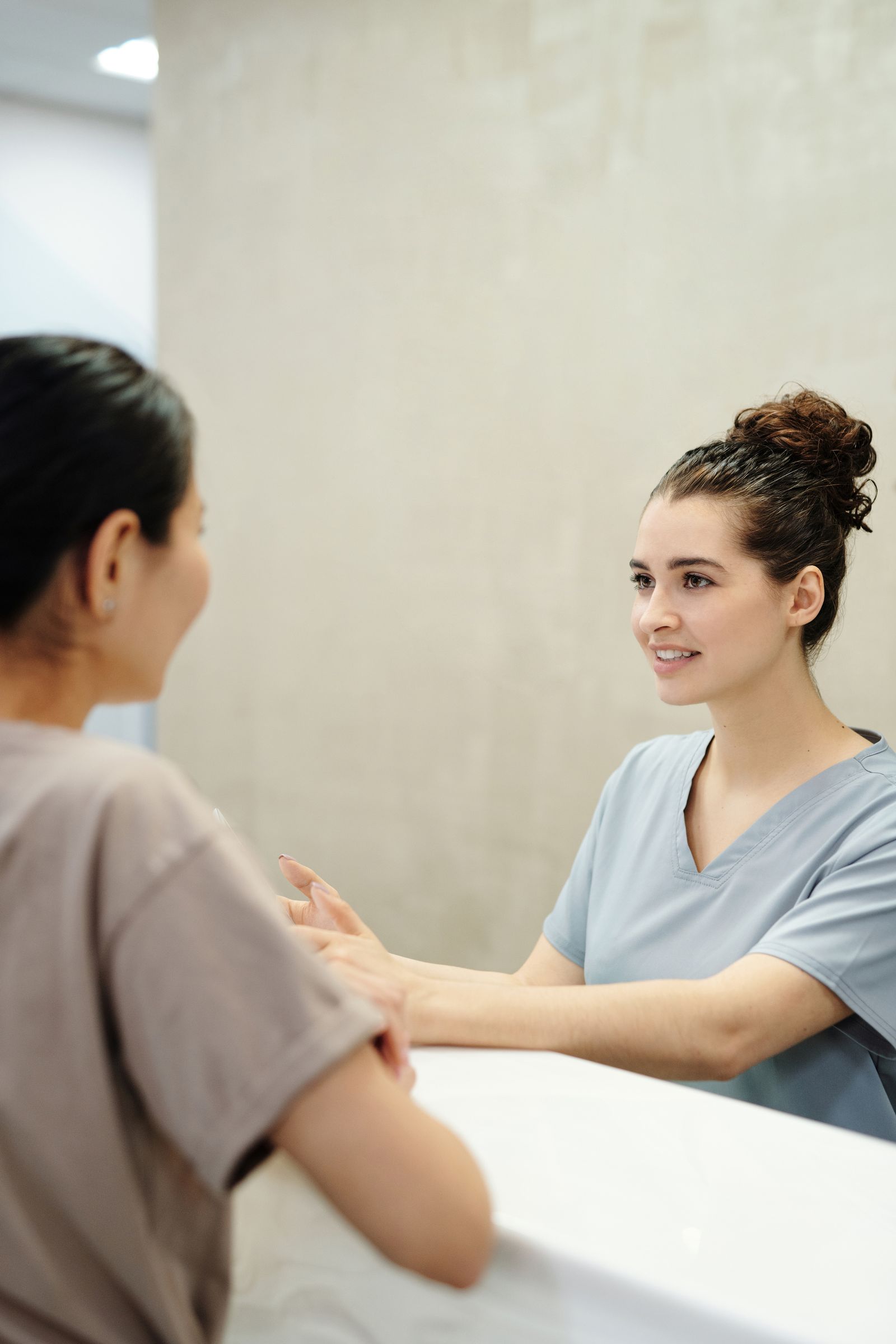 A patient talking with a clinician at the front desk