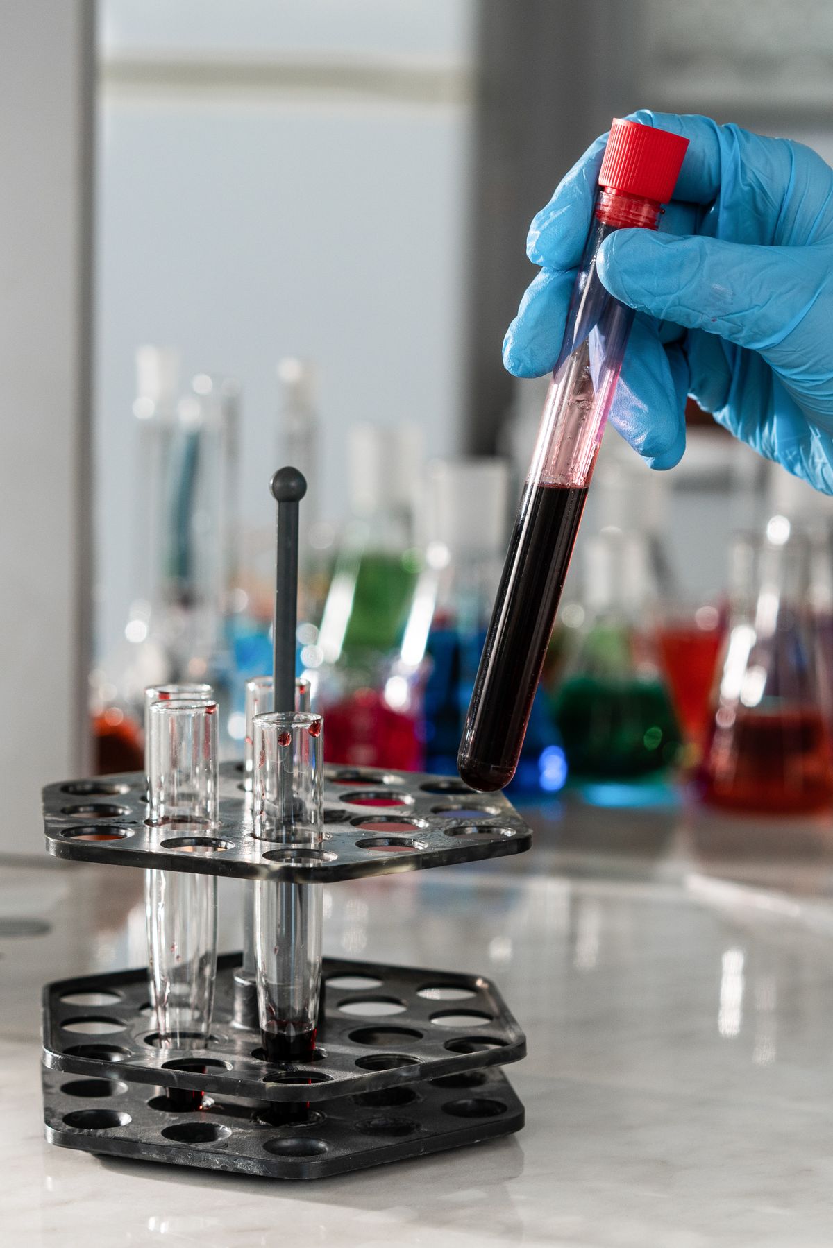 A gloved hand holding a test tube